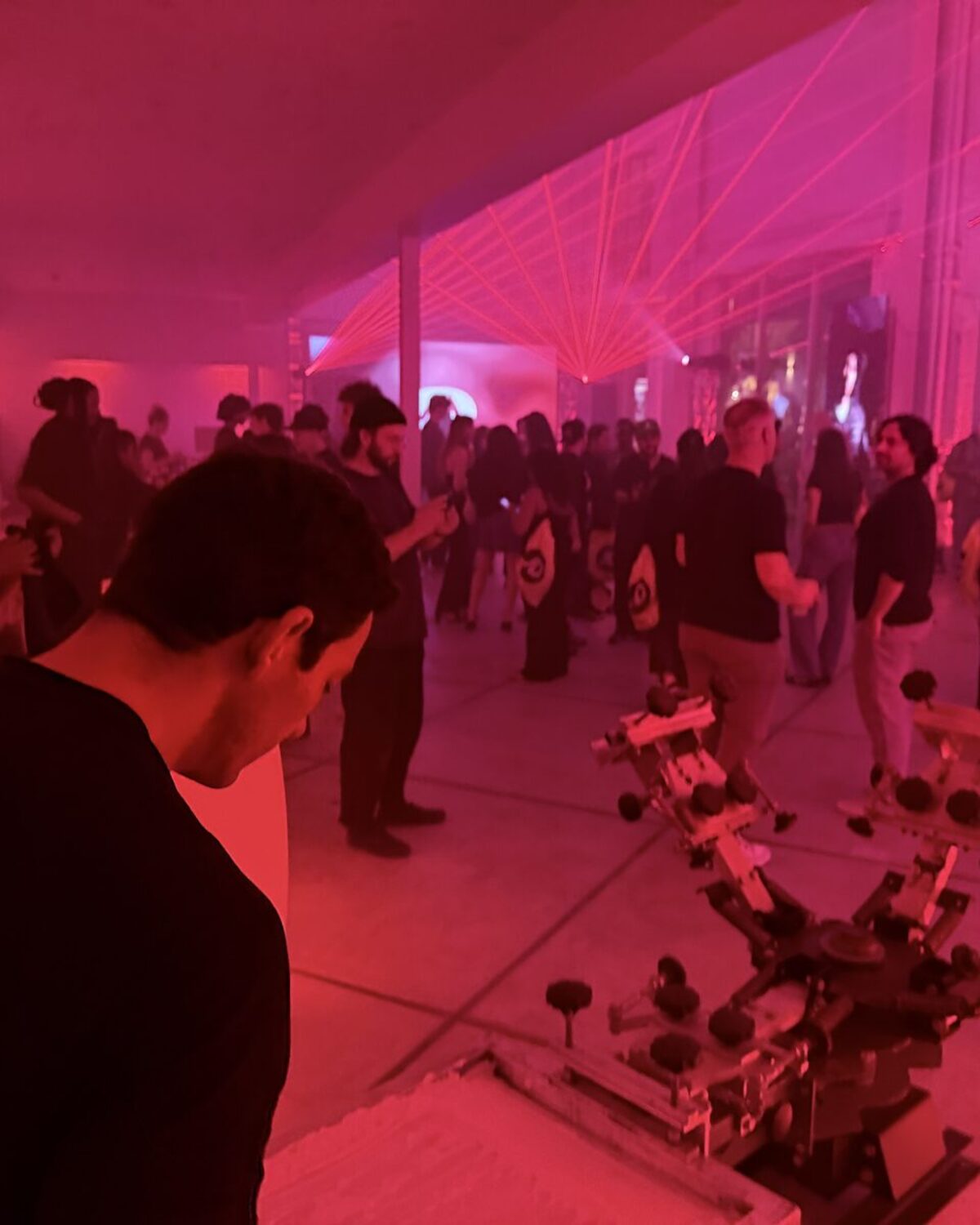 Personalization station holding its own beside a crowded pink-lit dance floor